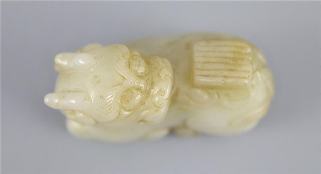 A Chinese pale celadon jade figure of a recumbent qilin, 5.4cm